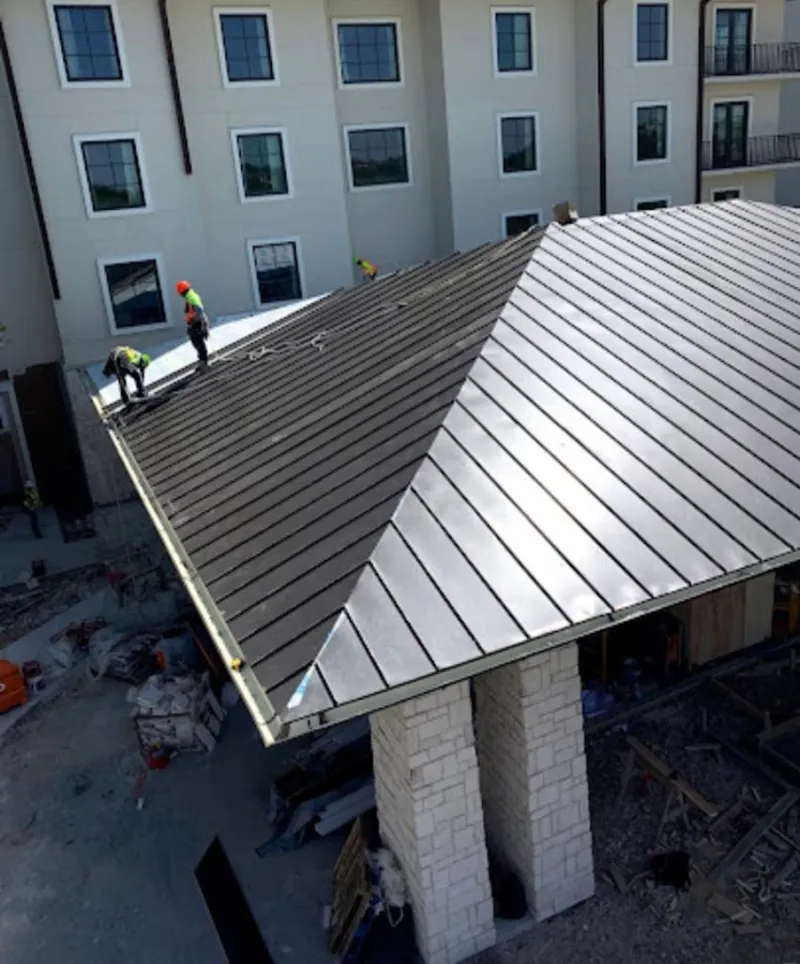 Crew installing standing seam metal roof panels on a commercial project in Calumet Park